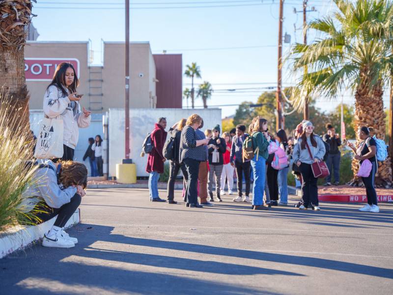 LAS VEGAS, NEVADA - DECEMBER 06: People wait on the outskirts of the UNLV campus after a shooting on December 06, 2023 in Las Vegas, Nevada. According to Las Vegas Metro Police, a suspect is dead and multiple victims are reported after a shooting on the campus. (Photo by Mingson Lau/Getty Images)